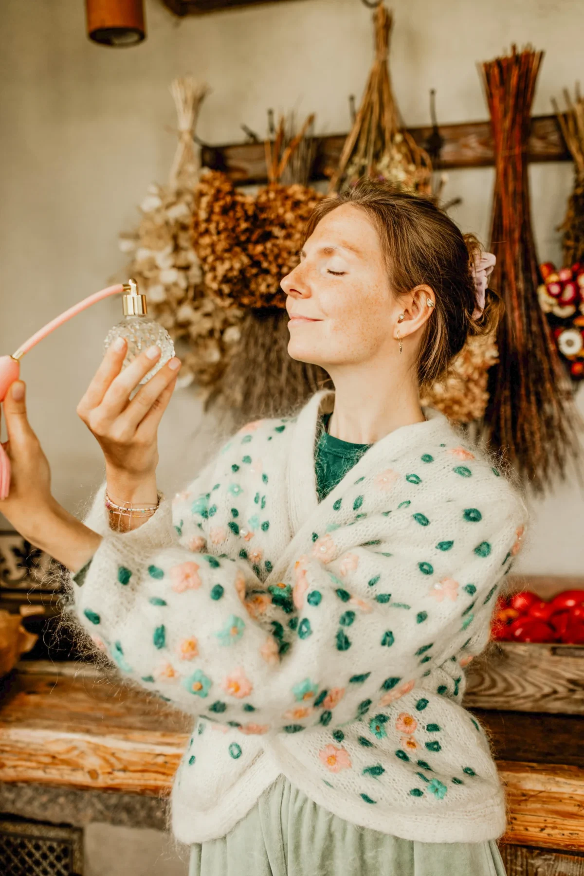 Tworzenie naturalnych perfum z olejków eterycznych – kobieta testuje własny zapach podczas warsztatów perfumiarskich