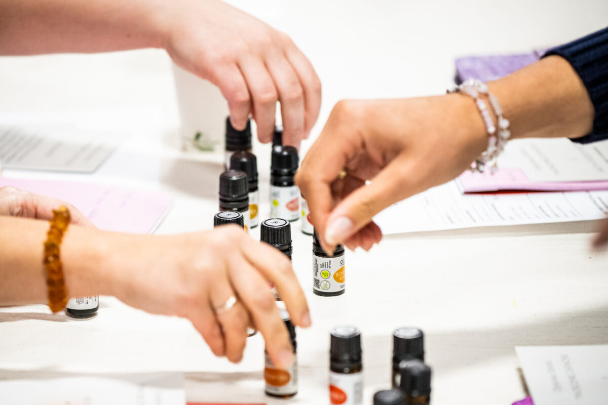 dłonie przy stole z olejkami – warsztaty perfumiarskie w Krakowie