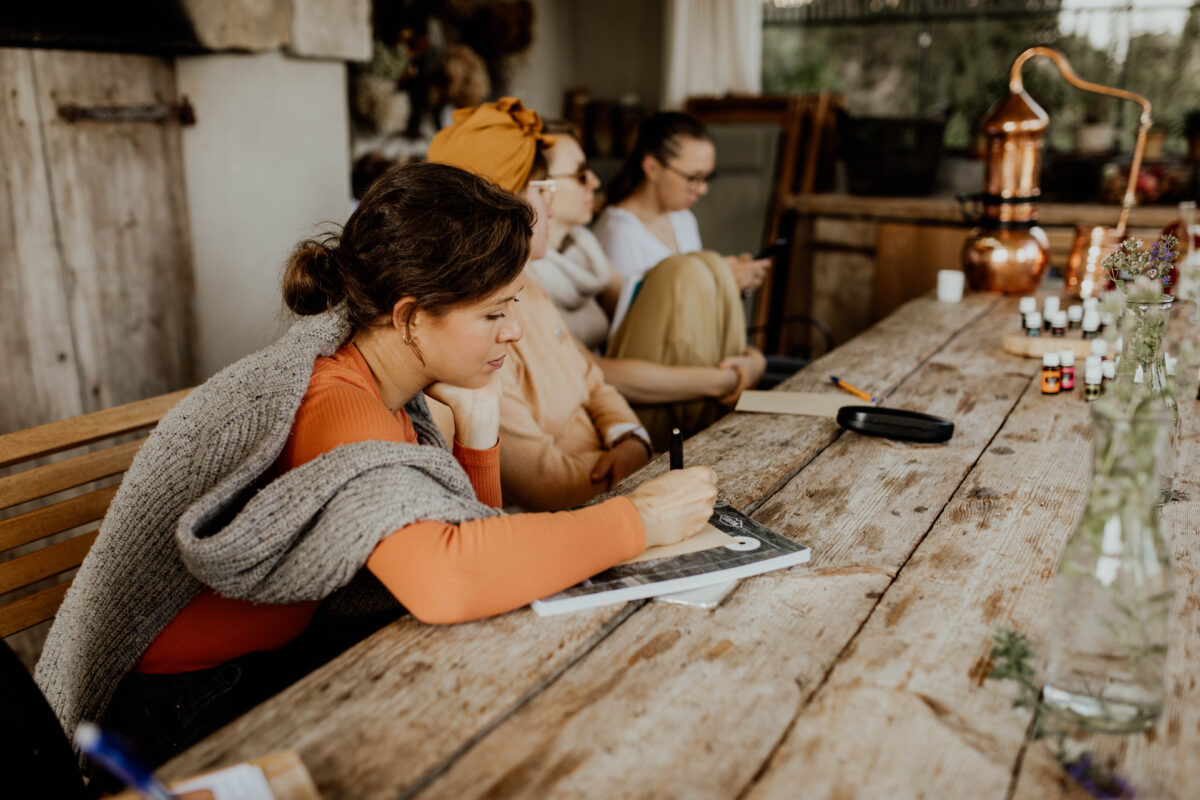 uczestniczki warsztatu robienia perfum zapisują receptury perfum przy stole