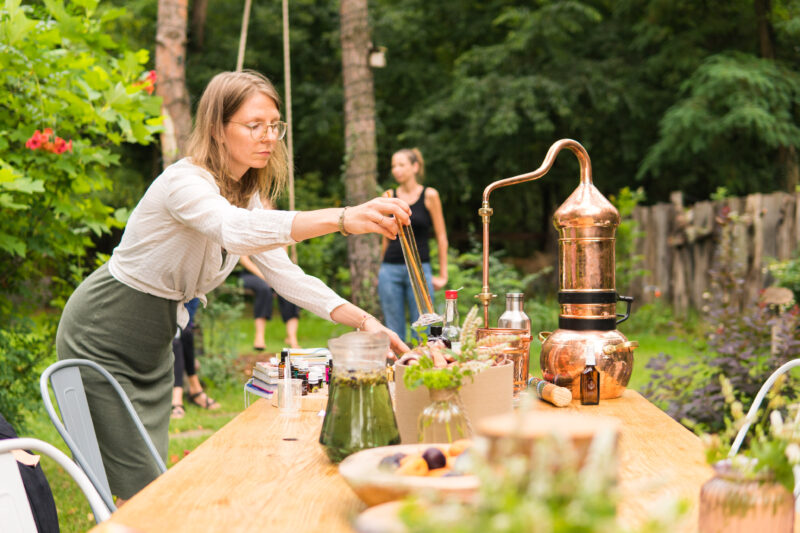 Prowadząca pokazuje proces destylacji podczas warsztatu aromaterapii