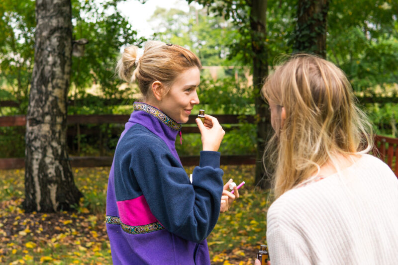Uczestniczki warsztatów aromaterapii testujące zapach olejków w ogrodzie