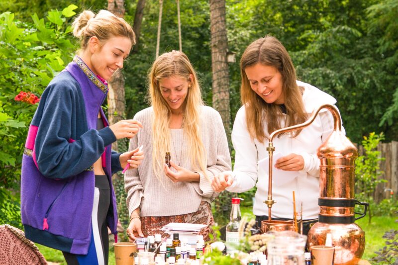 Trzy kobiety tworzące własne mieszanki zapachowe podczas warsztatów aromaterapii