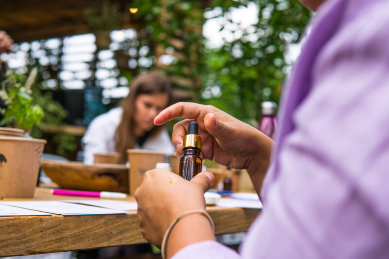 Kobieta komponująca mieszankę zapachową z olejków eterycznych na warsztatach